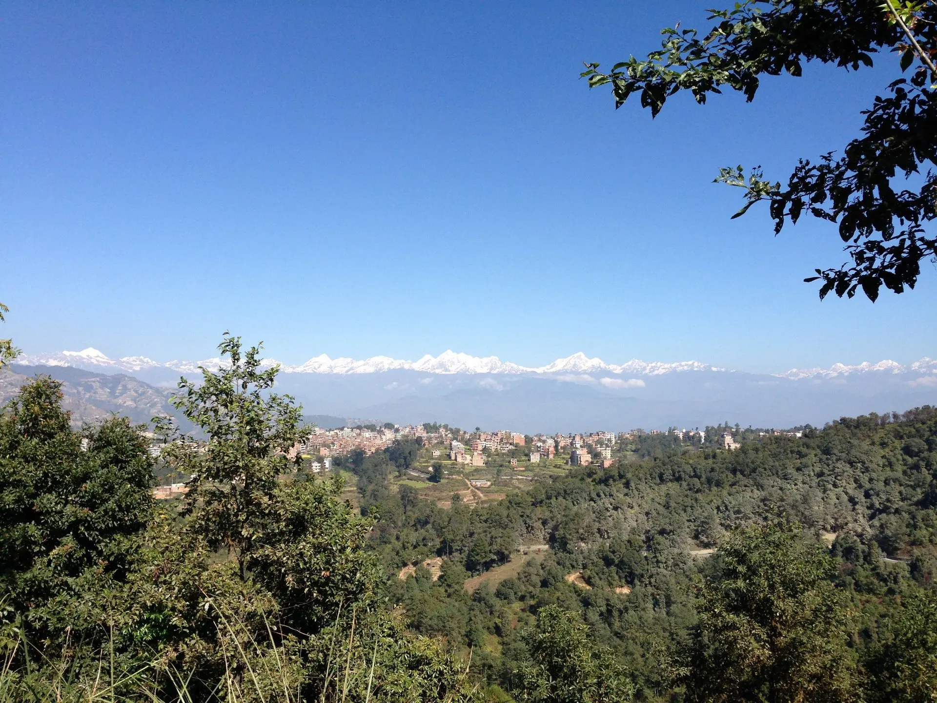 Weitsicht über eine Nepalesische Stadt mit Bergen im Hintergrund