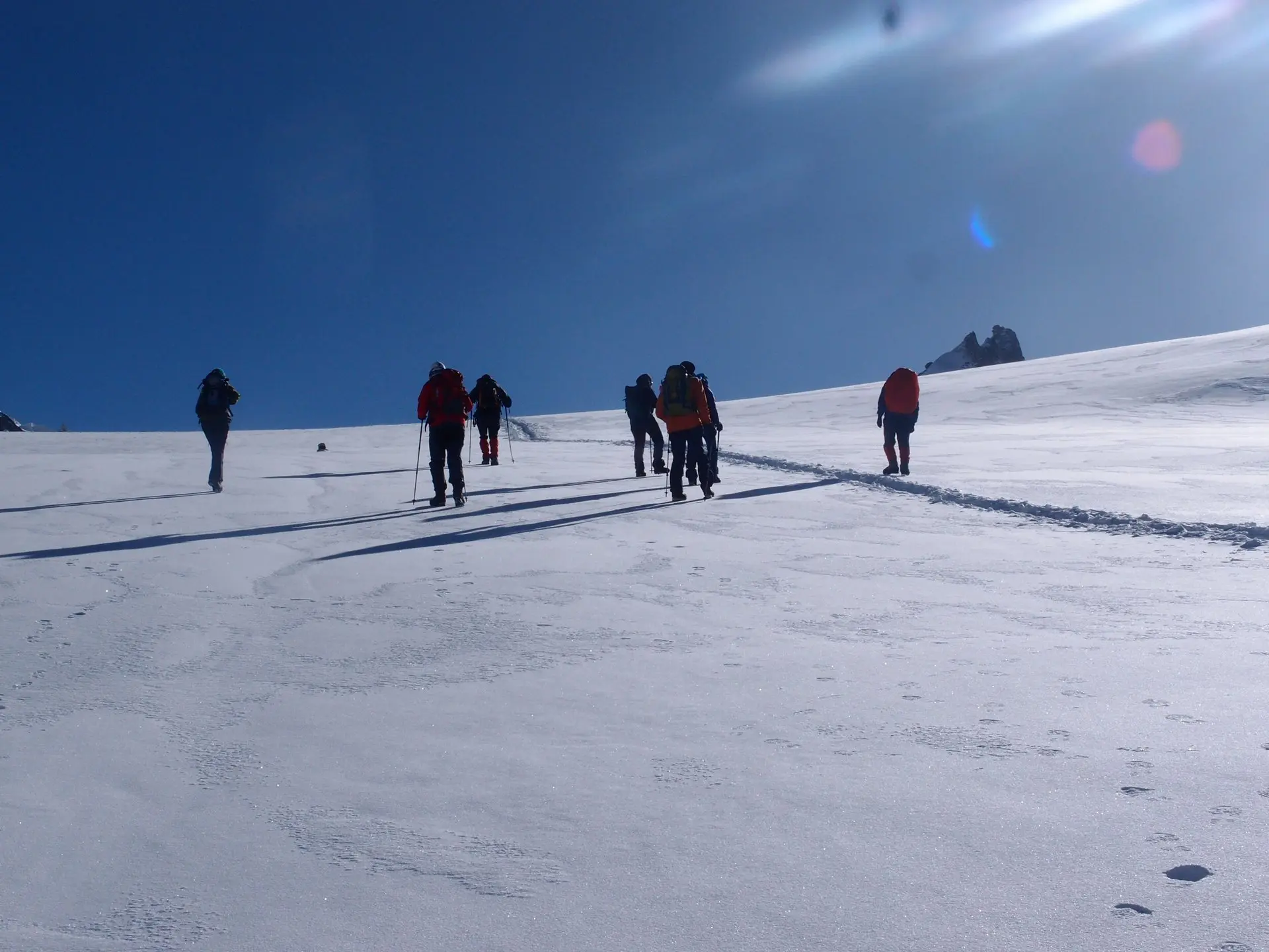 Mehrere Personen die über eine flache, schneebedeckte Fläche laufen