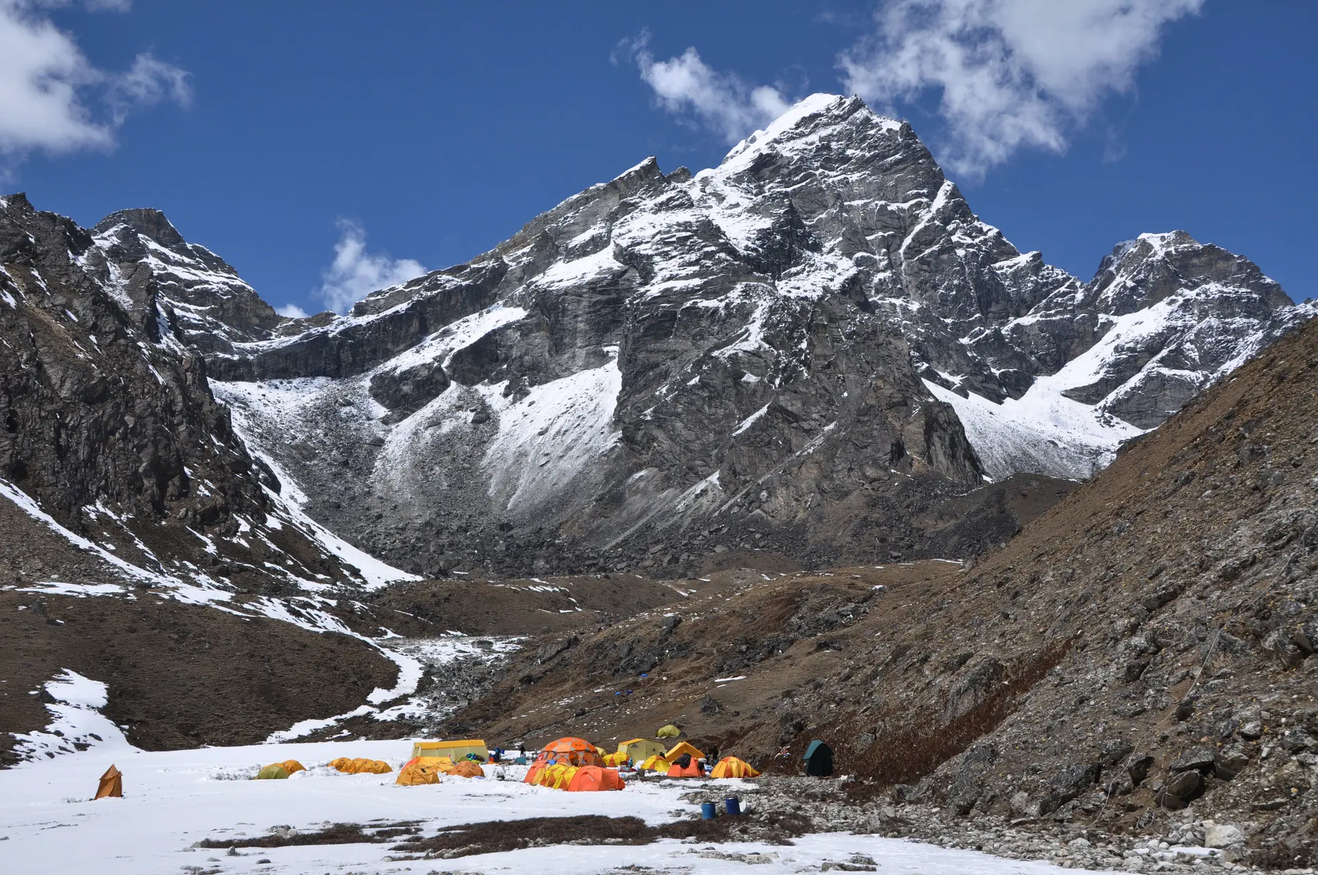 Schneebedeckte Berge mit Zelten am Fuß des Berges