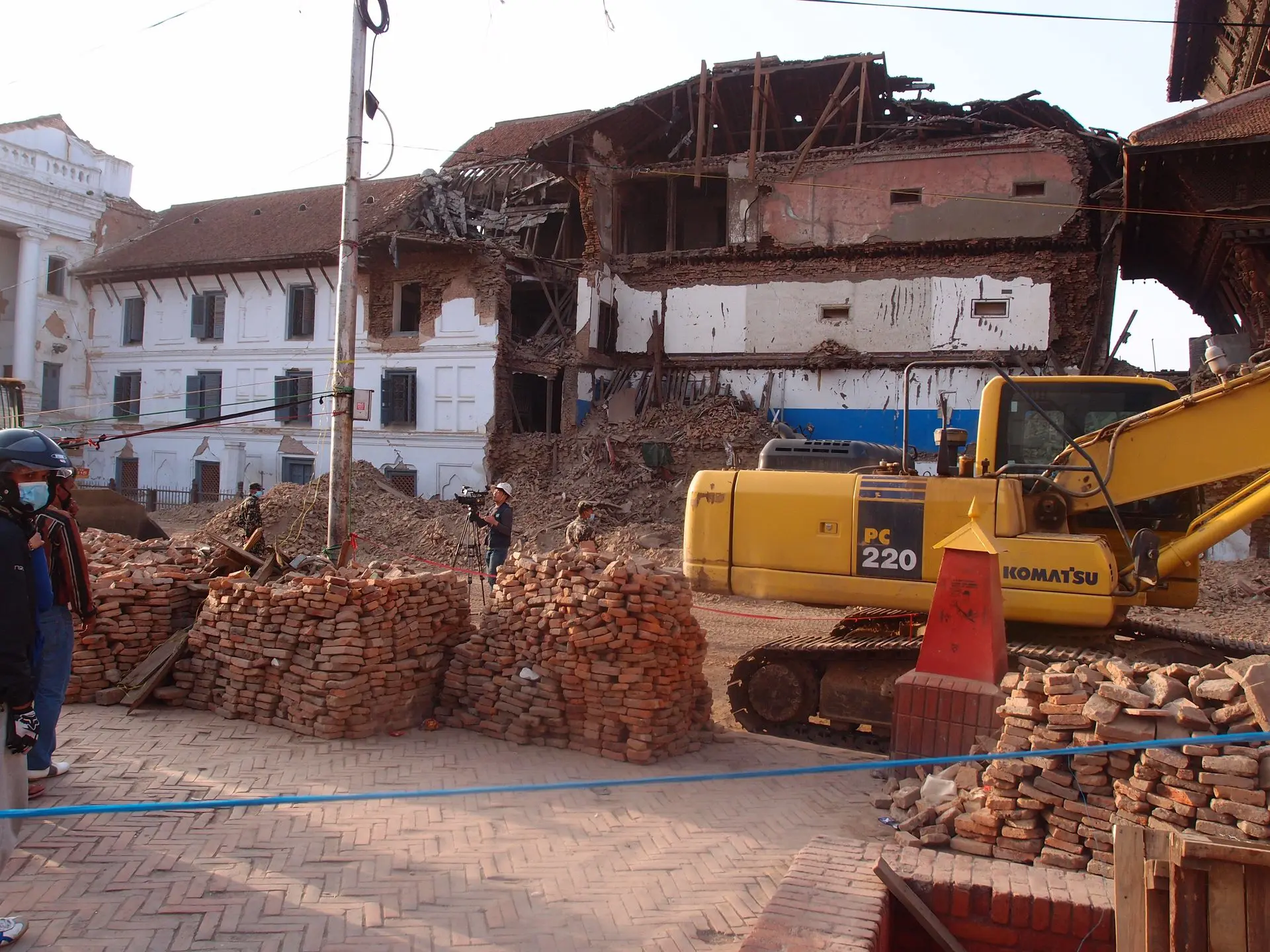 Kaputte Gebäude nach dem Erdbeben und ein Bagger
